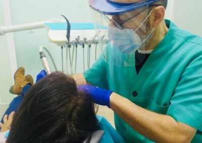 dentista realizando tratamiento a paciente en clinica con proteccion facial