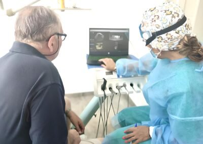 personal medico mostrando resultados en pantalla a paciente en consulta navas dental